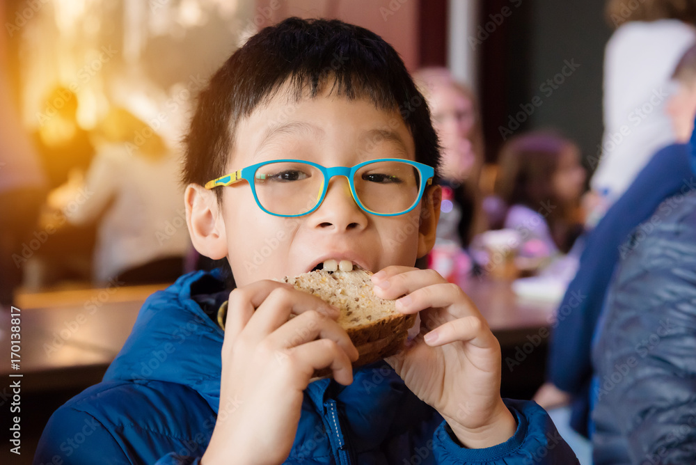 亚洲小男孩午餐吃三明治