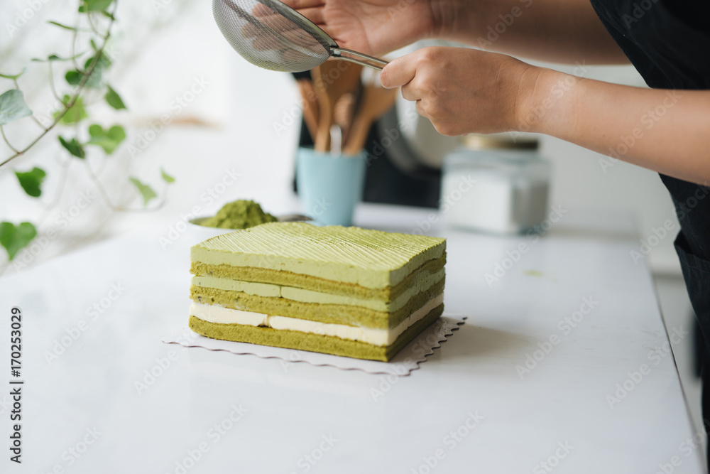 将绿茶粉浇在美味的芝士蛋糕上