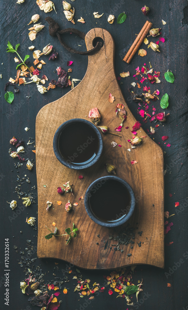 黑色木制背景上的服务木板上的黑色石墙杯中的中国红茶