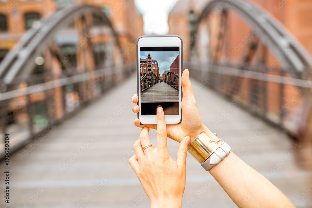 德国汉堡，一名女子用智能手机拍摄旧铁桥
