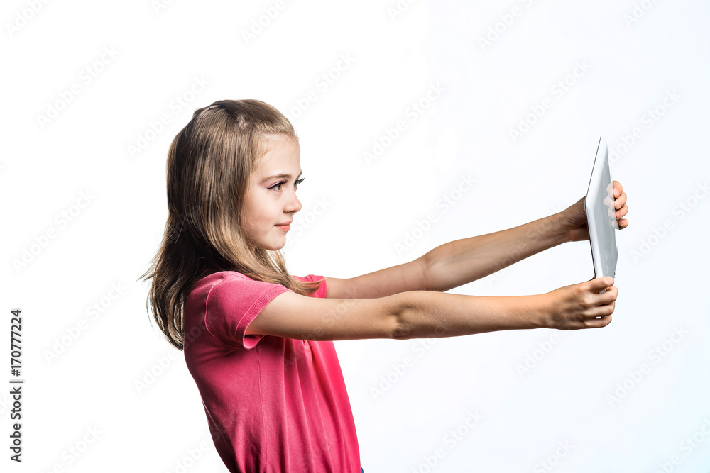 白色背景下拿着平板电脑的小女孩。孩子的情绪。