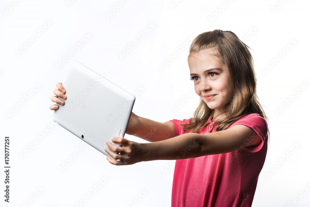 Little girl with a tablet computer on a white background. Emotions of the child.