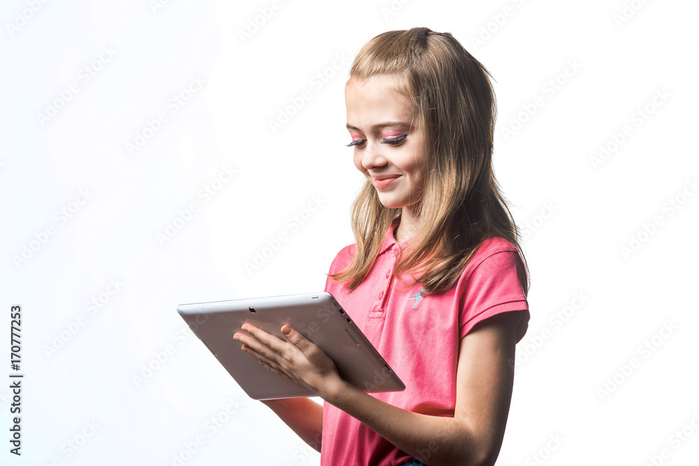 白色背景下的小女孩，拿着平板电脑。孩子的表情和微笑。