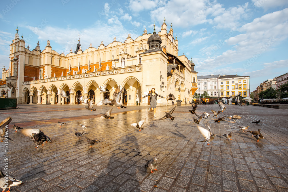 波兰克拉科夫市市场广场上的布艺大厅与鸽子的晨景
