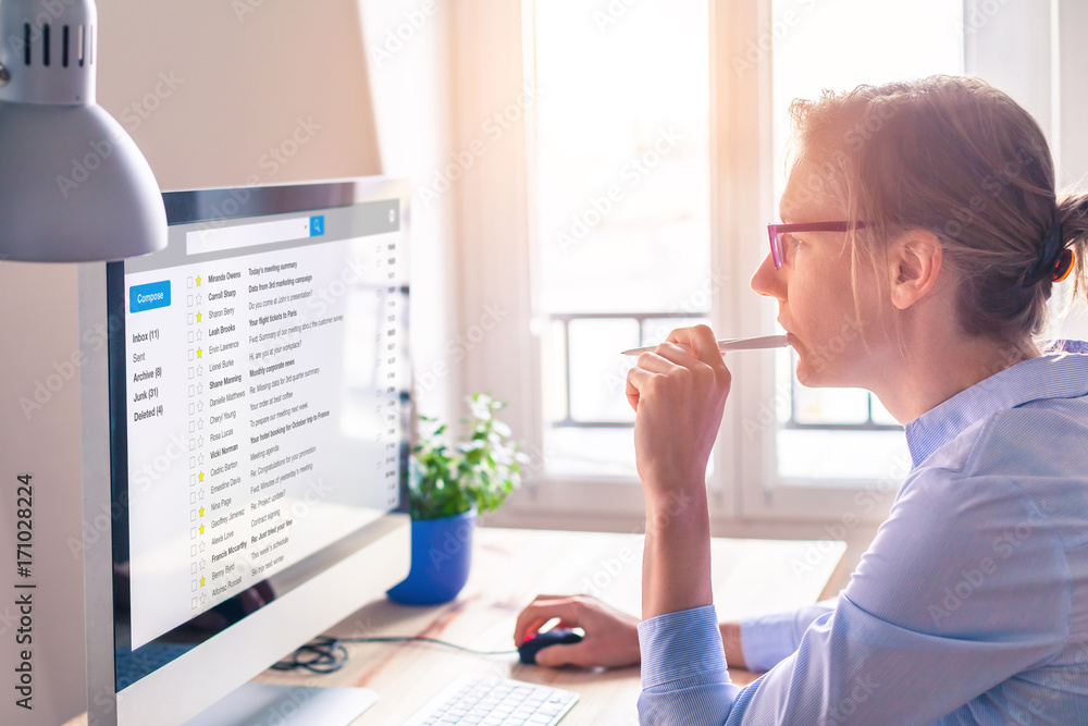 女性商务人士在工作时在电脑屏幕上阅读电子邮件