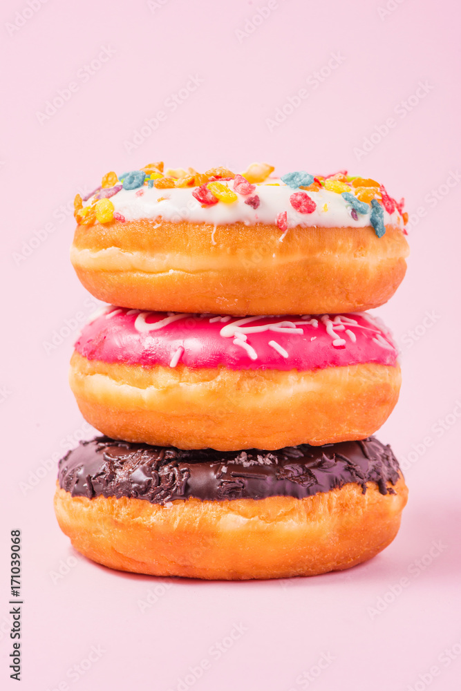淡粉色背景的生日美味甜甜圈。
