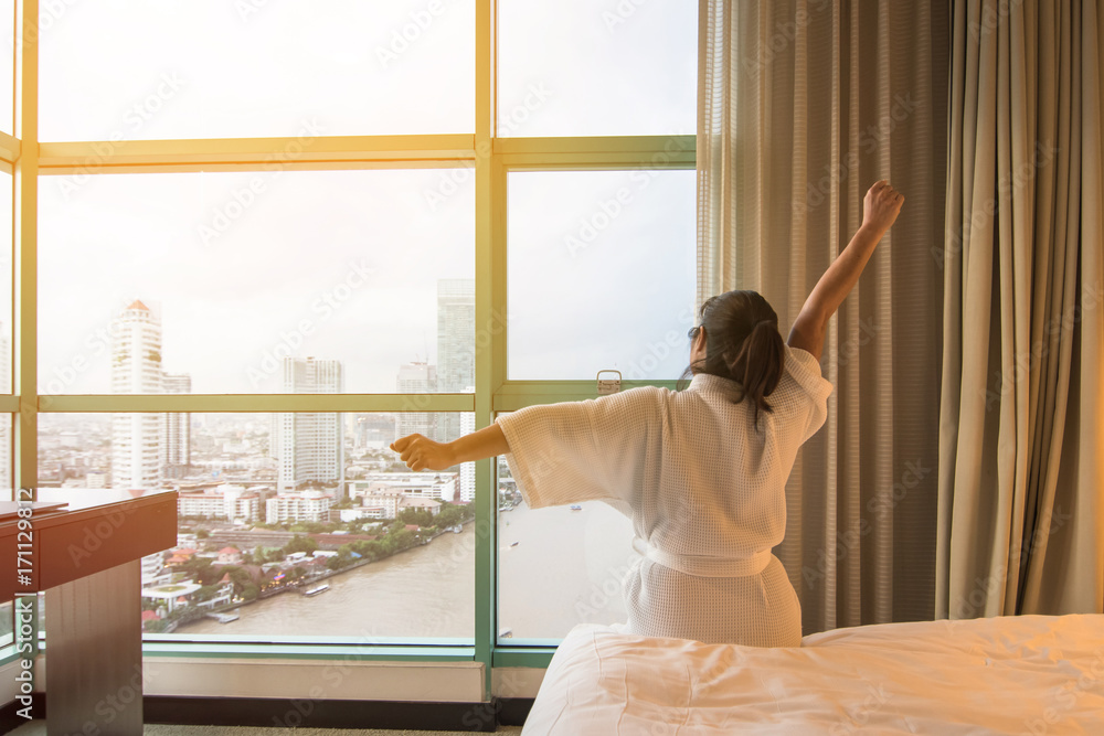 轻松的生活方式亚洲女性早上醒来，在酒店房间或家里的床上休息