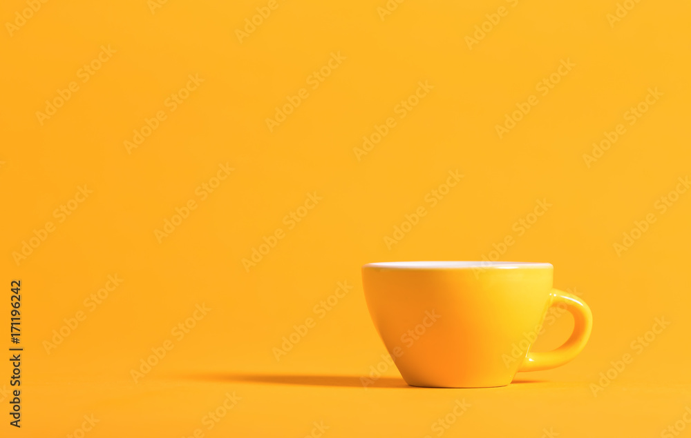背景明亮的黄色小茶杯