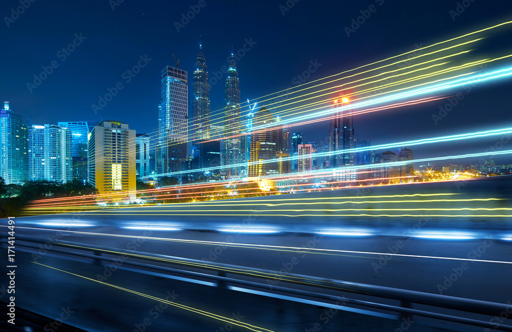View from Side of flyover,blurred motion effect  with light trails and beautiful city skyline backgr