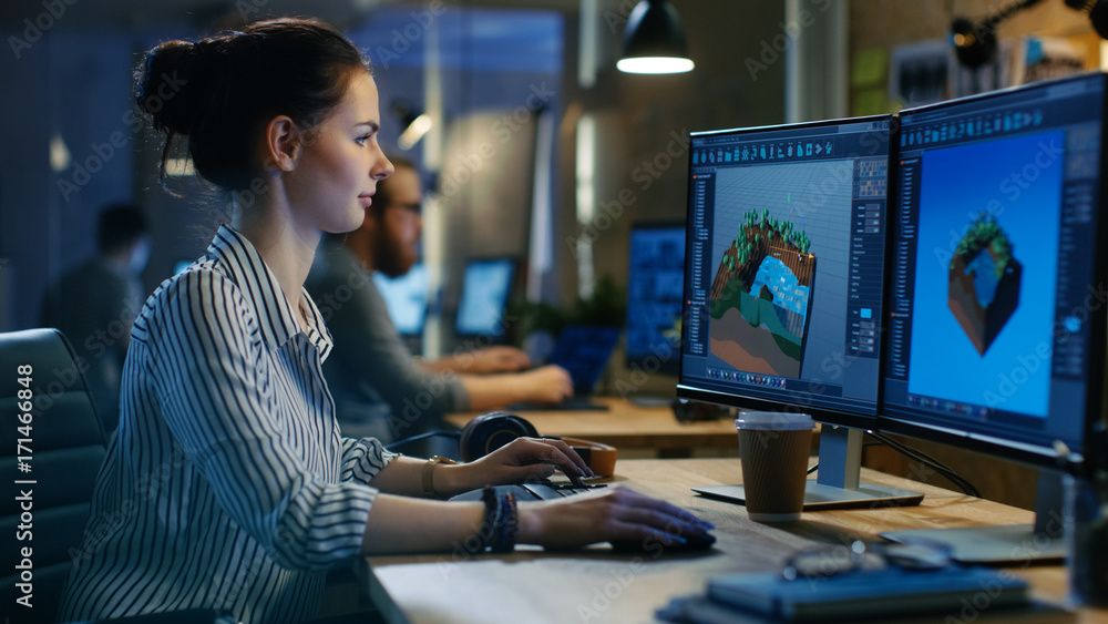 女性游戏开发人员在她有两个显示器的个人电脑上进行关卡设计。她工作