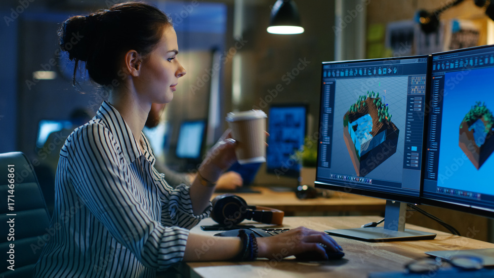 女性游戏开发人员在她的个人电脑上进行两个显示器的关卡设计，她工作