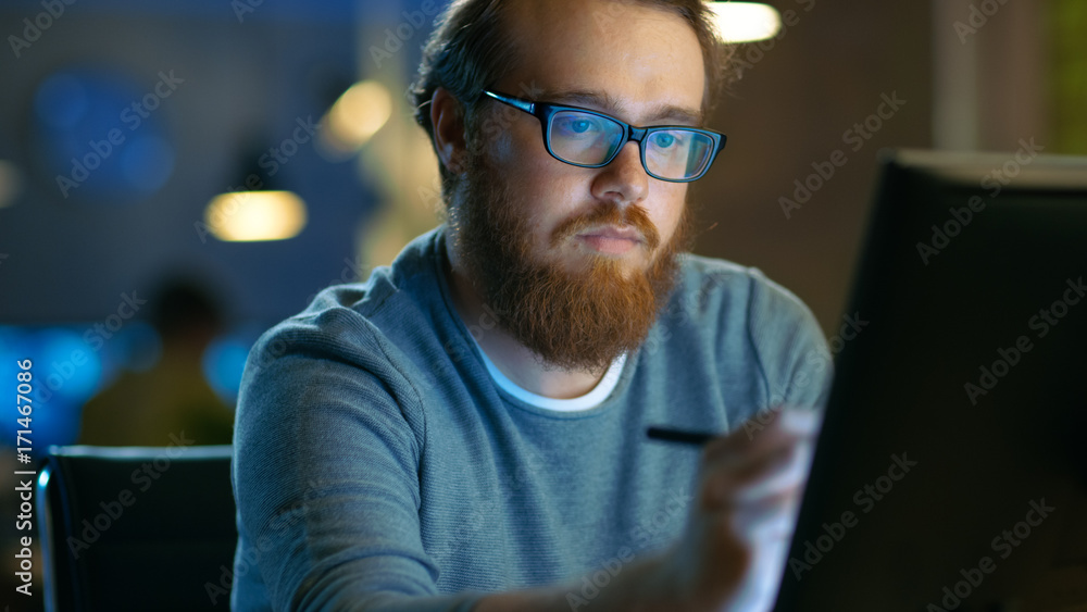 才华横溢的年轻概念艺术家坐在工作台上用数码笔在平板电脑上画画