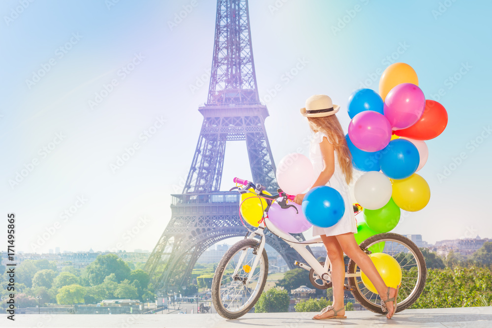 女孩带着五颜六色的气球在巴黎骑行