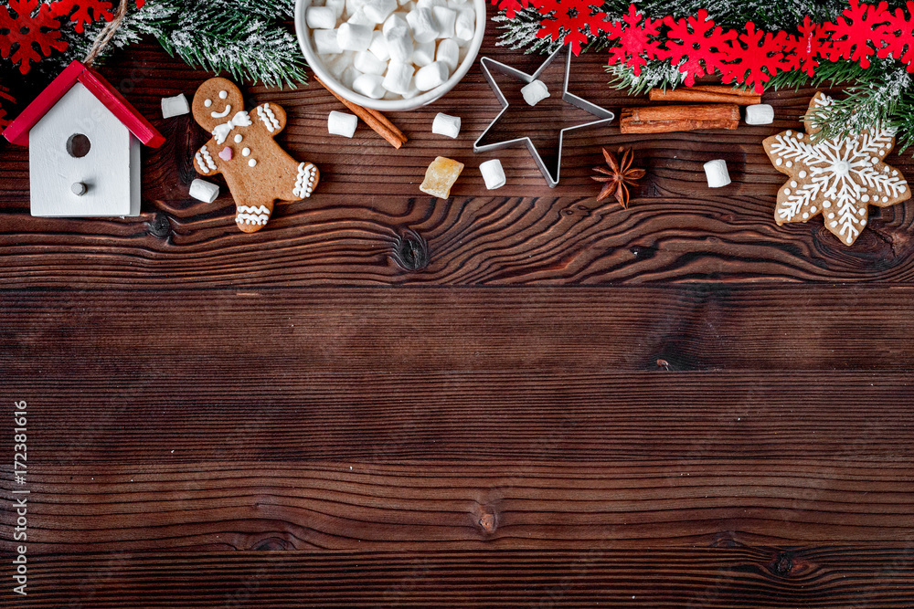 Christmas gingerbread, spruce branches on dark wooden background