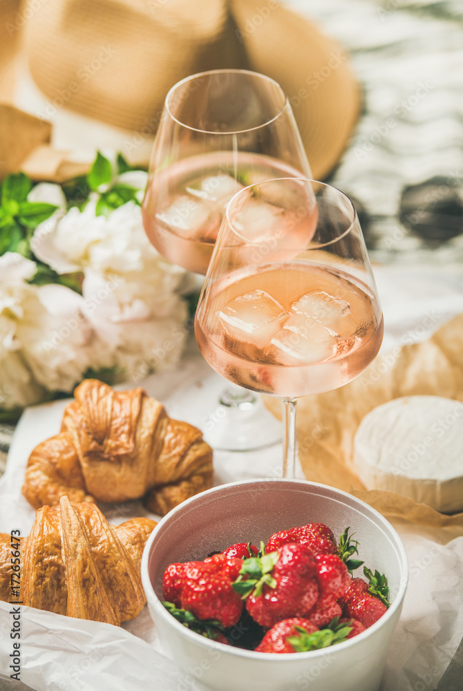 法式浪漫的夏季野餐环境。一杯加冰块的玫瑰酒，新鲜的草莓