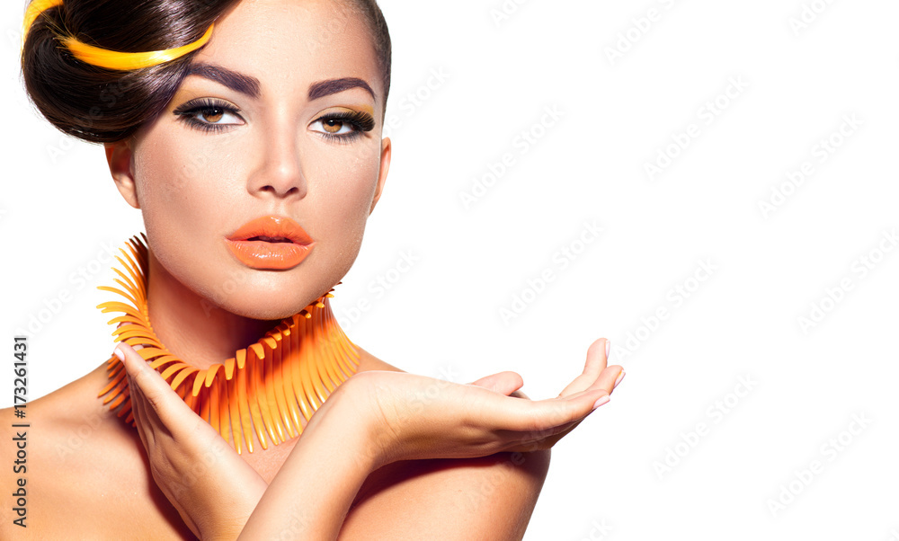 Fashion model girl with yellow and orange makeup. Creative hairstyle