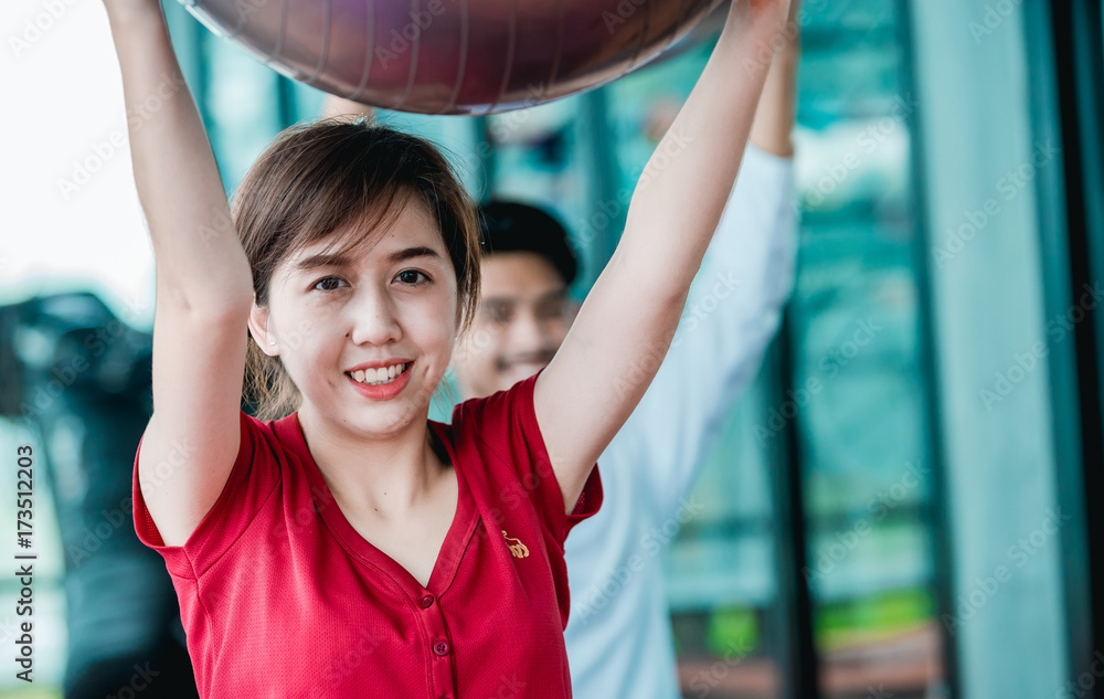亚洲少女在健身中心快乐地用健身球锻炼身体。