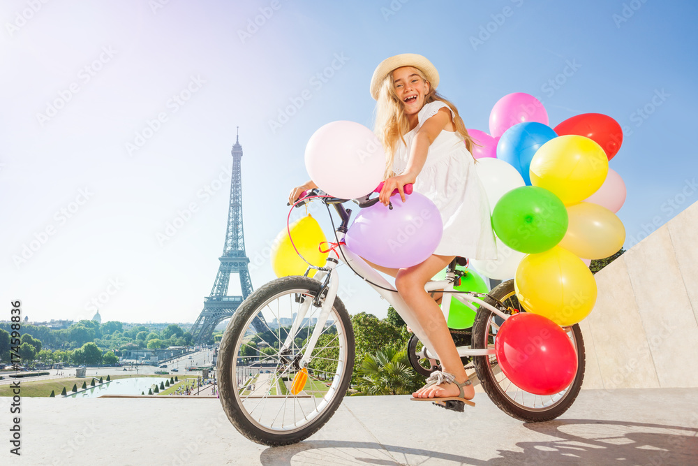 快乐的法国女孩骑着五颜六色的气球