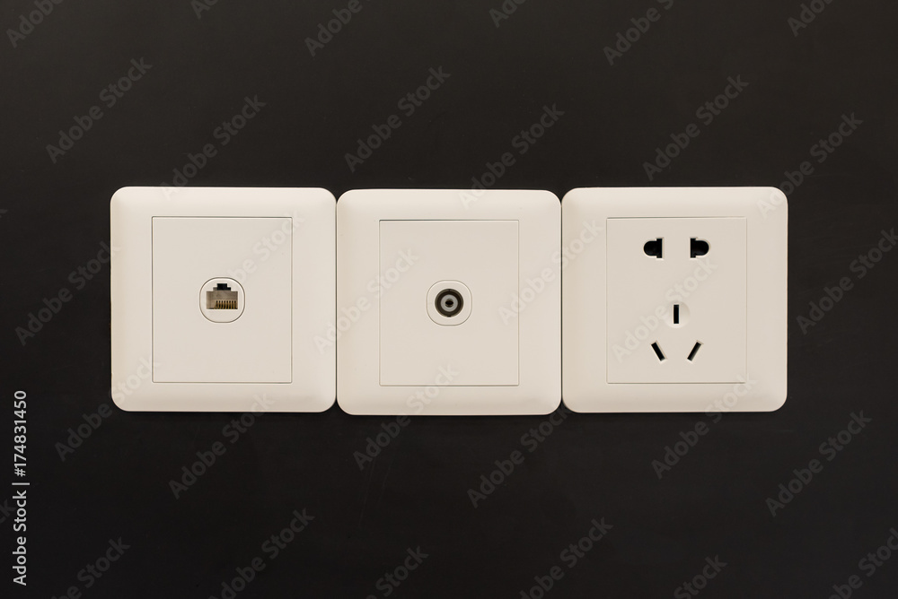 墙上的白色电源插头或插座，带电视和电话