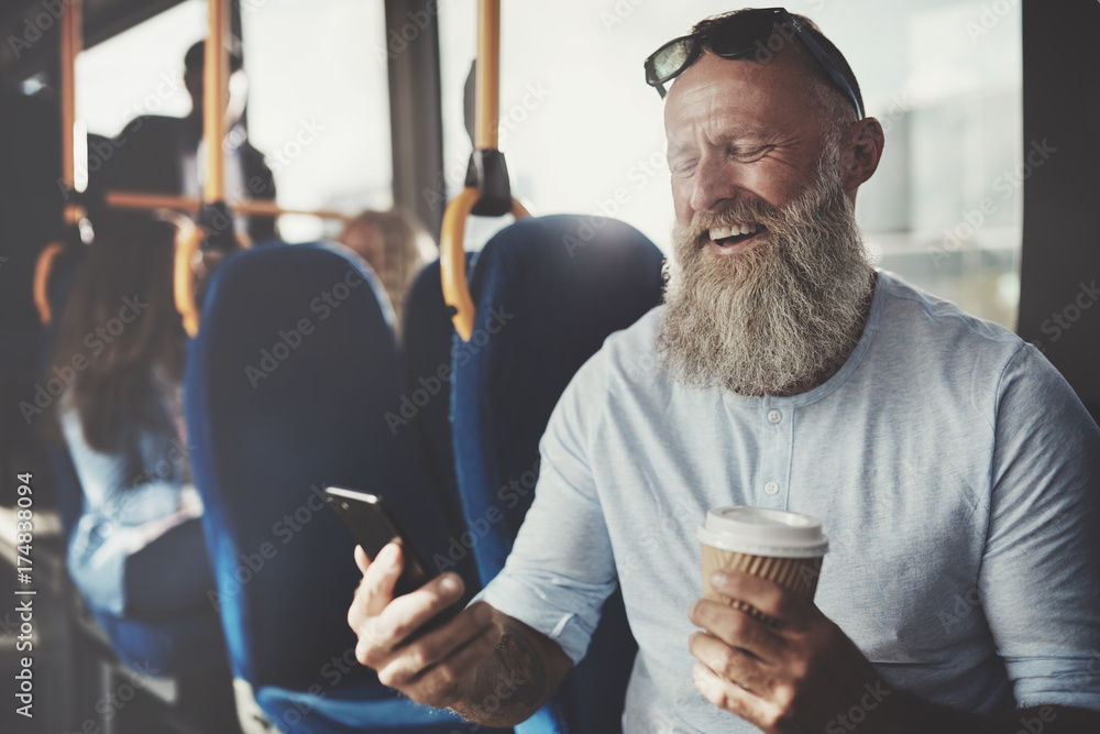 大胡子男子在公交车上用手机大笑