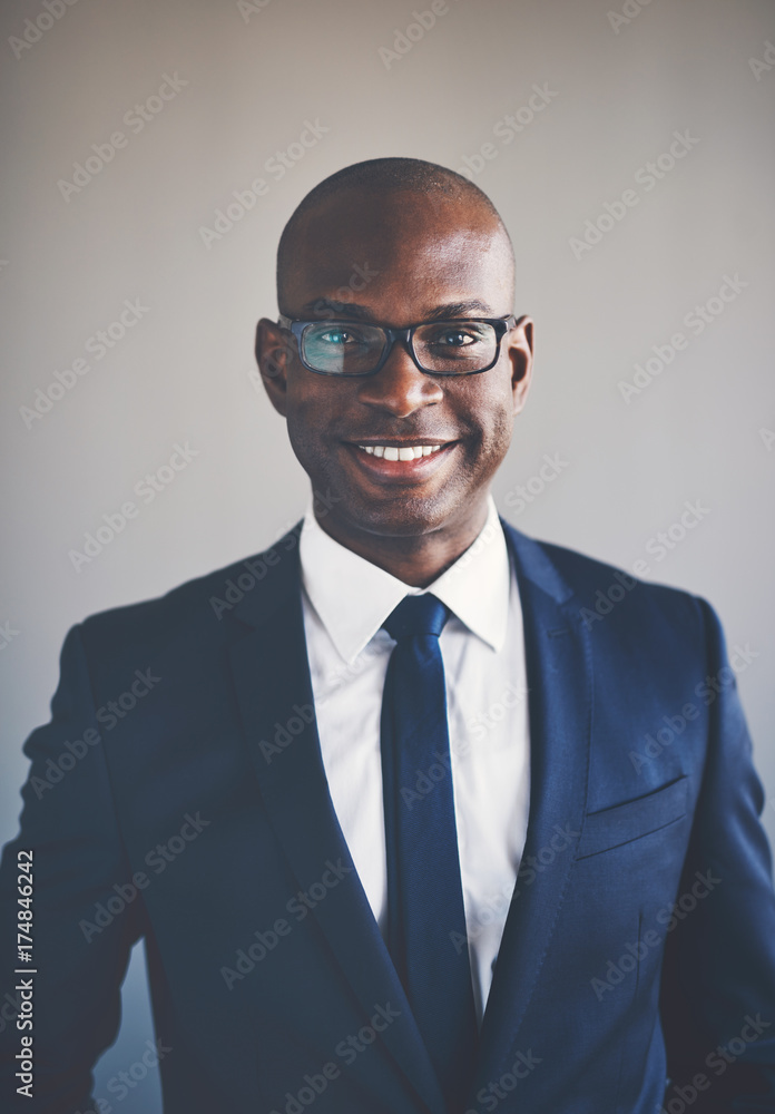 微笑的年轻非洲高管，穿着西装，戴着眼镜