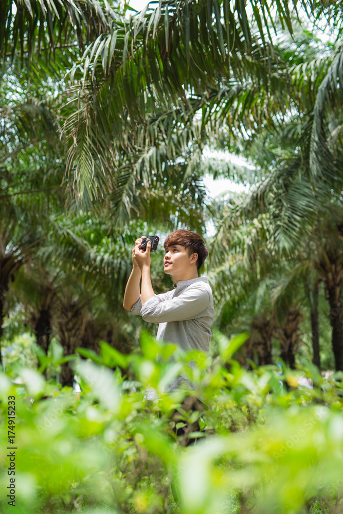亚洲青年摄影师在公园拍照