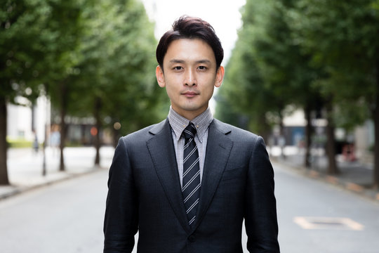 portrait of young asian businessman on street