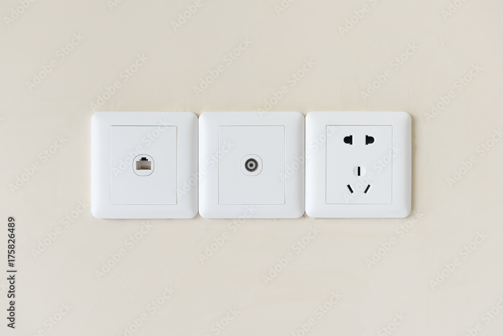 墙上的白色电源插头或插座，带电视和电话