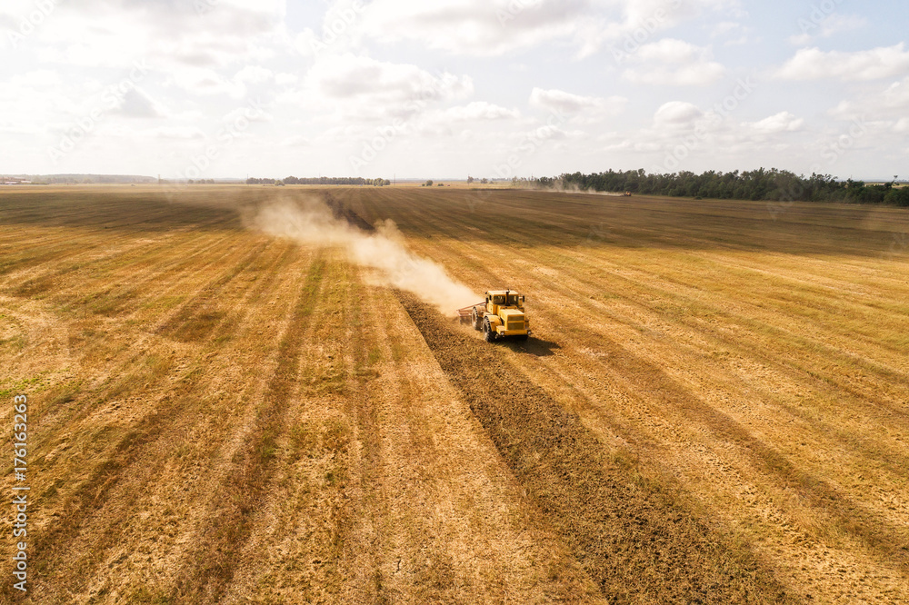 无人机拍摄的收割机在田地里的视频。拖拉机在耕地。俯视图