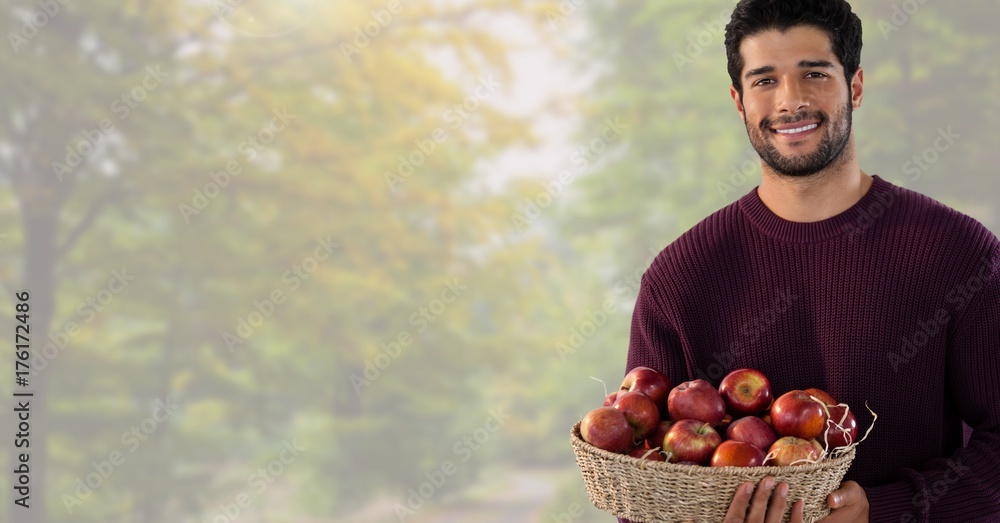 Man in Autumn with basket of apples in bright forest