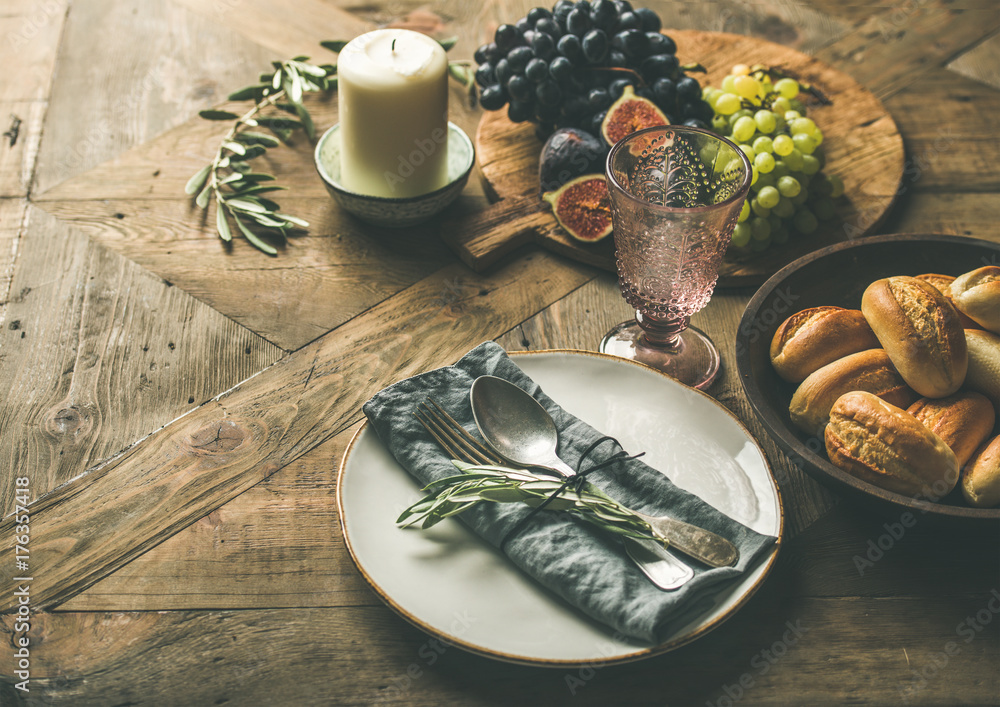 秋季节日餐桌派对装饰设置。盘子里有亚麻餐巾、叉子、勺子、玻璃、蜡烛、gr