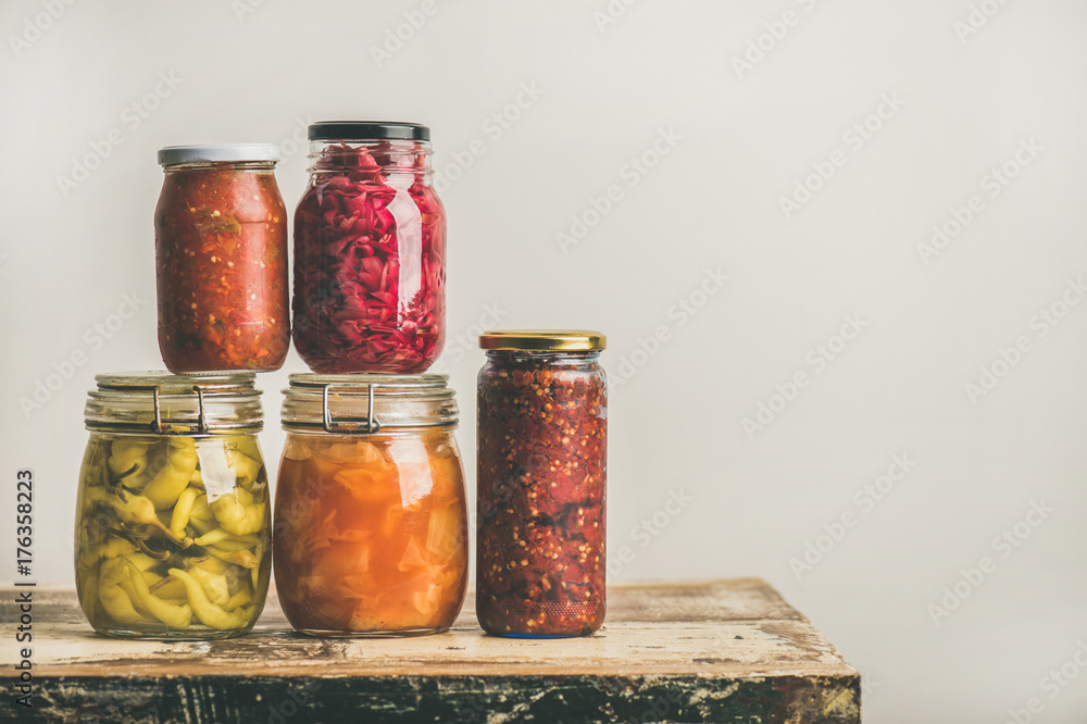 秋季时令腌制或发酵的彩色蔬菜，装在玻璃罐中，叠放在年份上