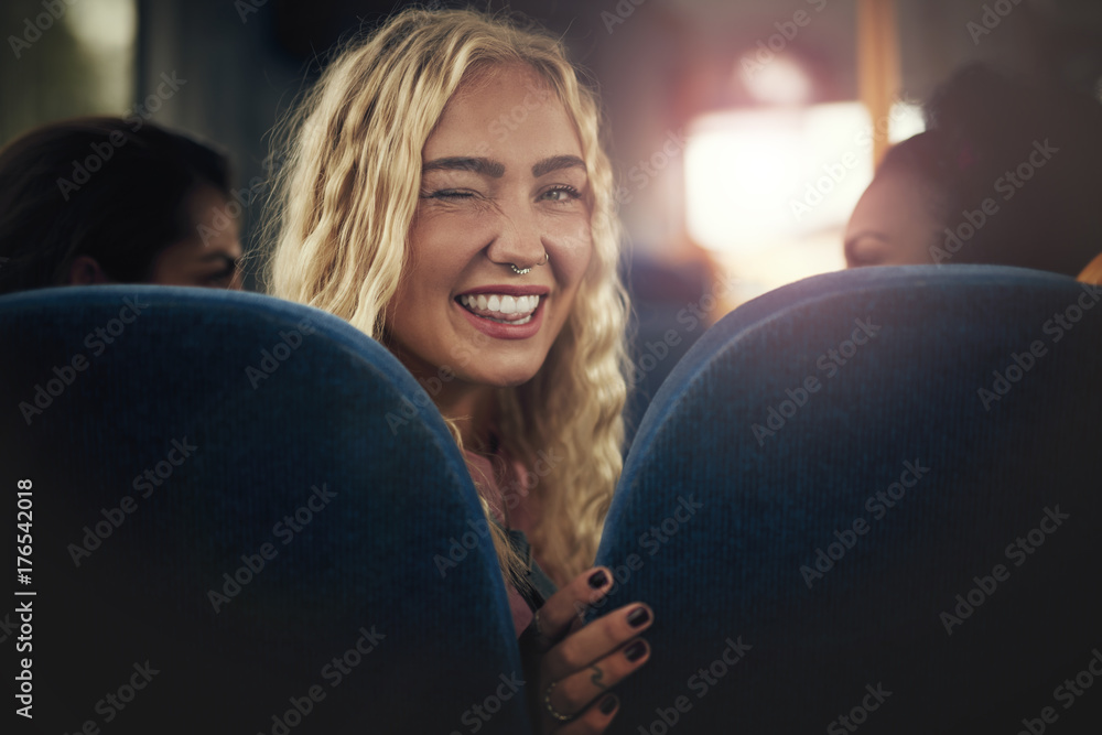 坐在公交车上微笑眨眼的年轻女子