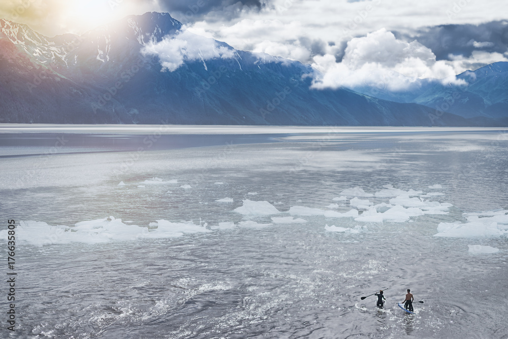 一对夫妇在去苏厄德的路上，在阿拉斯加的湖中玩桨板。