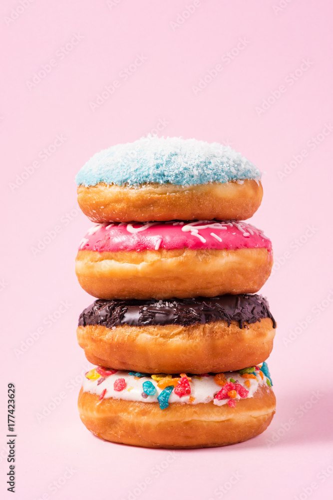 淡粉色背景的美味生日甜甜圈。
