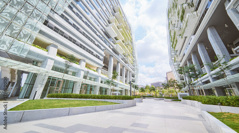 空荡荡的人行道和现代办公楼的低角度透视图，带有绿色生态概念balco