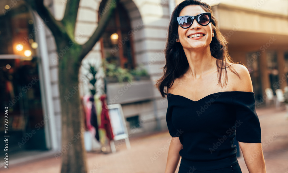 微笑的女人走在城市的路上