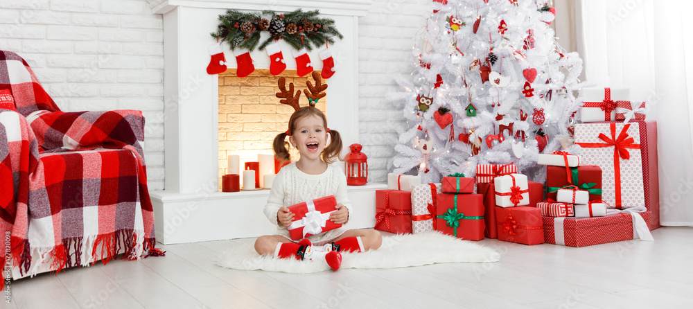 快乐的小女孩，早上在圣诞树前送礼物。