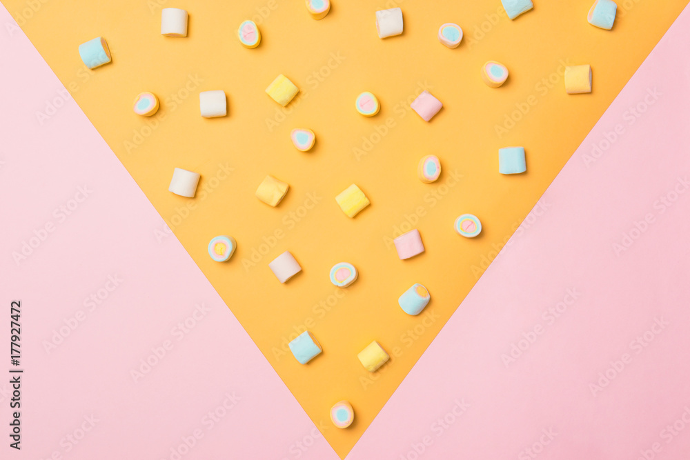 粉色和黄色背景的柔和棉花糖俯视图。简约风格。