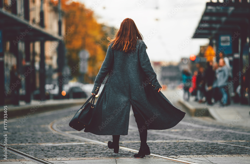 穿着外套的时尚女性走在街上，城市场景