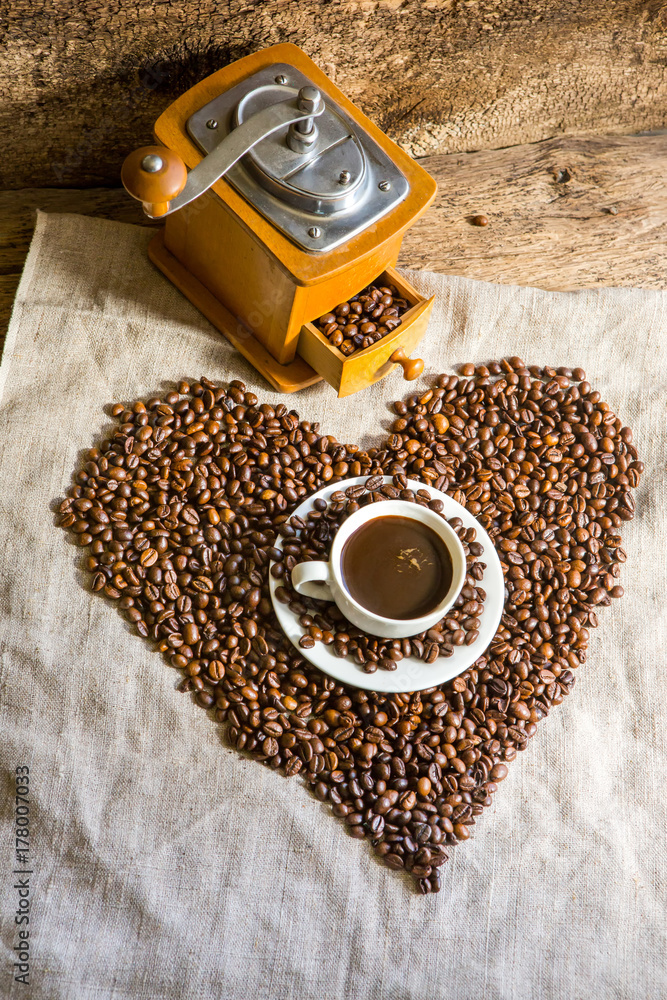 桌上的一杯热咖啡。早晨的咖啡。咖啡豆的成分。老式咖啡研磨机。