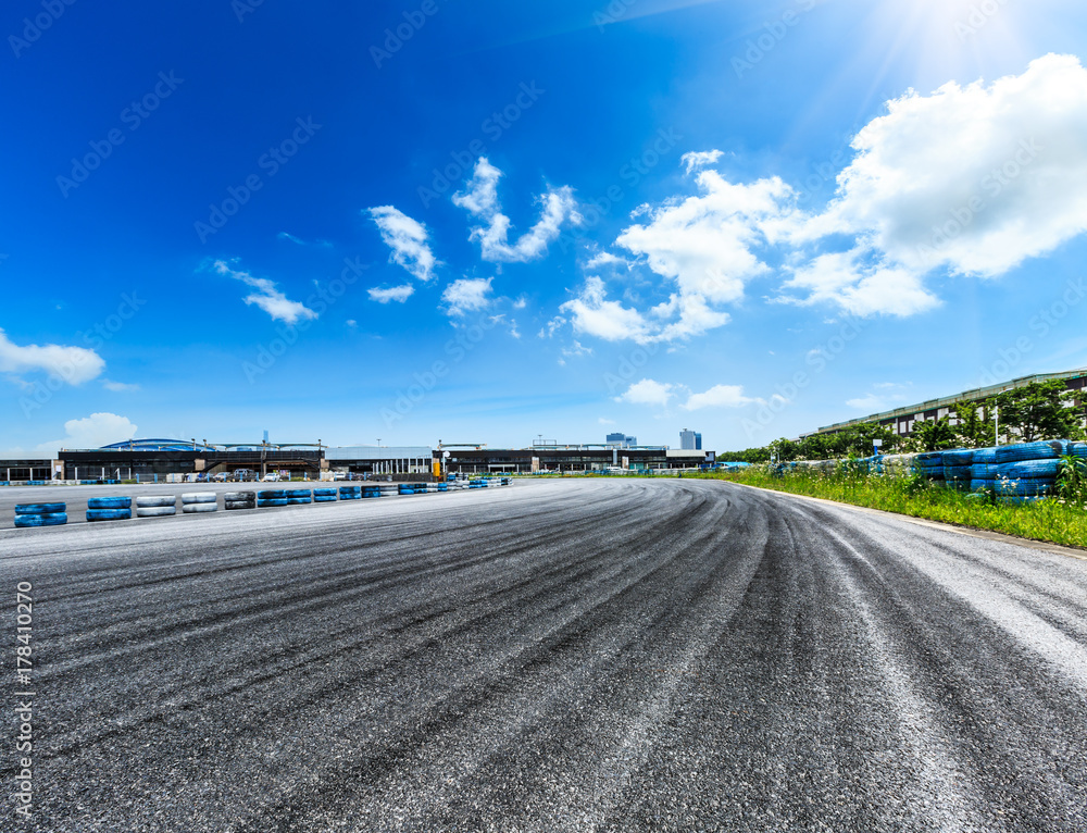 Asphalt road circuit and sky clouds with car tire brake
