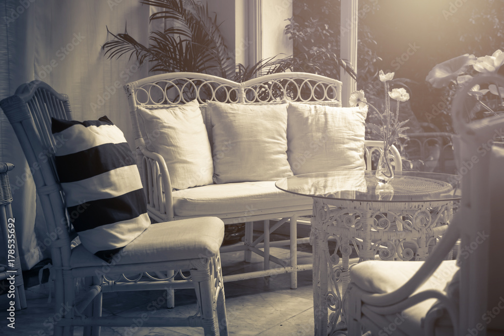 带椅子、沙发和桌子的家具休息室，位于庭院中，可欣赏花园背景