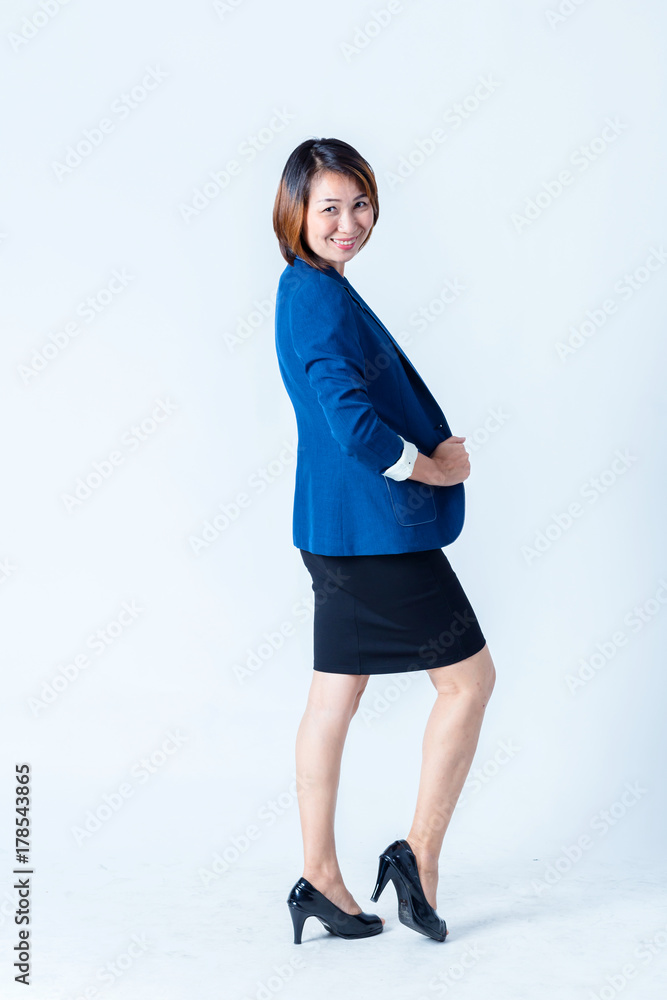 穿着蓝色西装的亚洲女人在工作室里摆出幸福的动作姿势，隔离白色背景