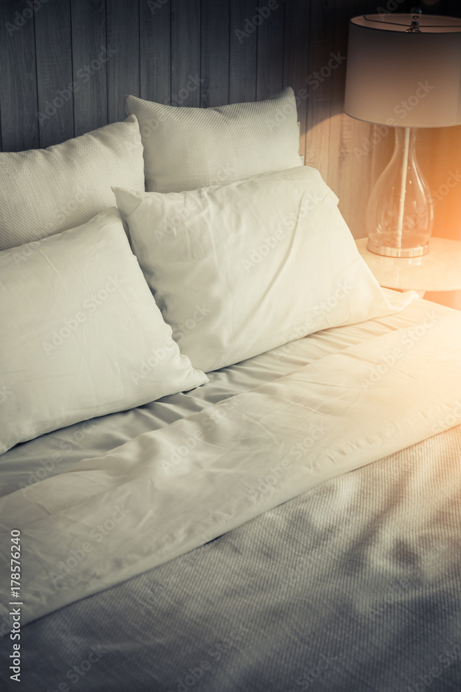 漂亮的卧室里有一个干净的白色枕头和床单的女仆。特写。镜头很有魅力