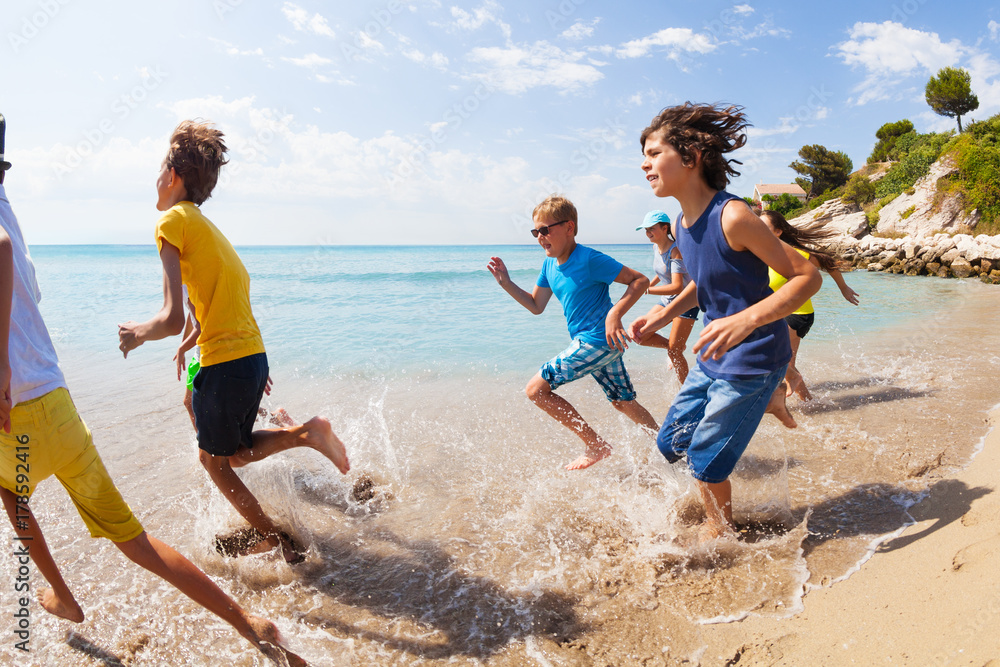 一群孩子在海滩水边跑步