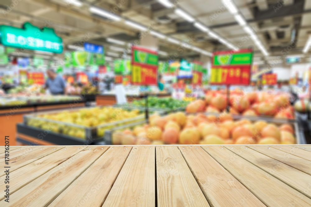 Empty wooden table and supermarket blurred fruits background
