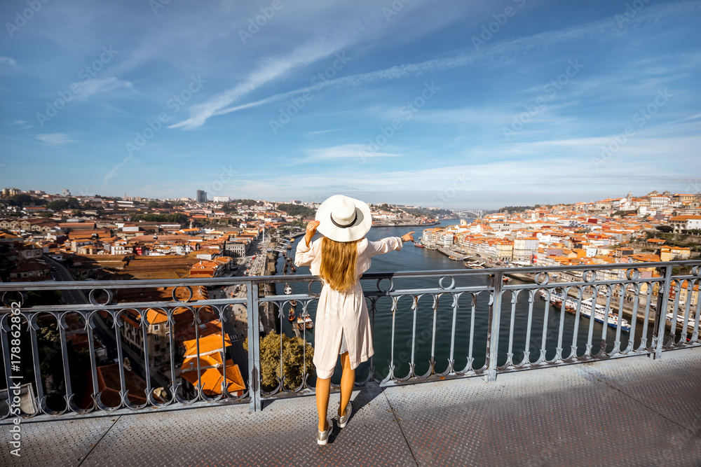 年轻的女游客站在铁桥上欣赏古城和杜罗河的美景