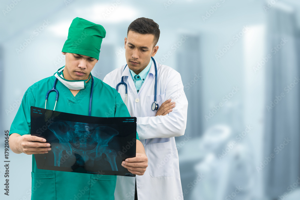 外科医生和医生正在看x光片。