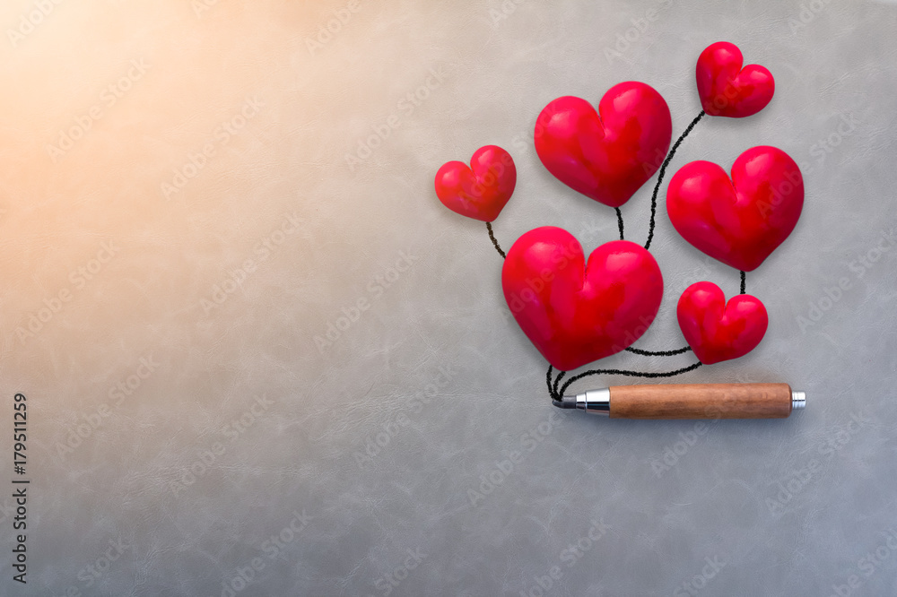 情人节概念，红色心形物体，灰色皮革背景上有木柄铅笔w